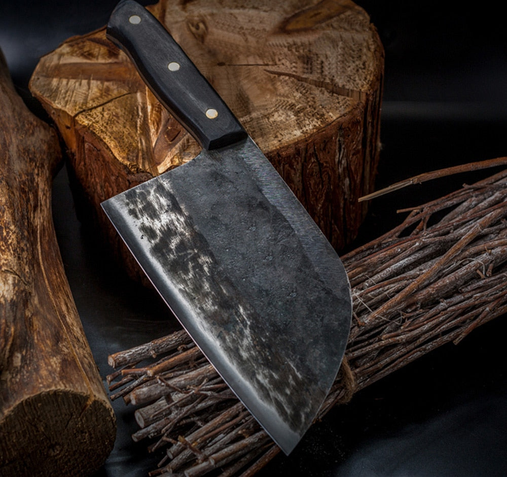 Knife with a textured blade and black handle on a wooden background