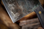 Close-up of the knife blade held by a hand against a blurred background