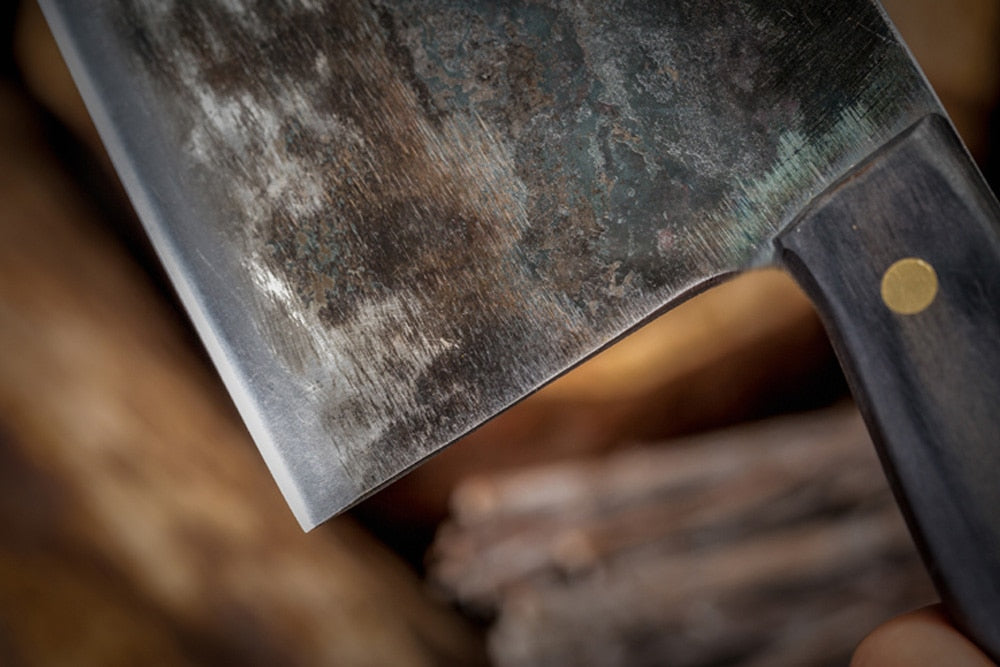 Close-up of the knife blade held by a hand against a blurred background